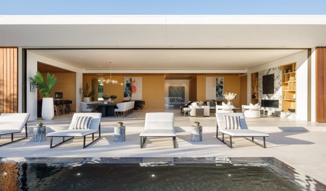 Residencia Delvin | Zona de la piscina con tumbonas y salón al fondo | XTEN Architecture | Alumilux