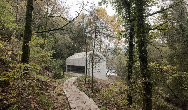 Casa en Caniçada. Vista exterior de la vivienda con rampa de acceso y rodeada de vegetación. Carvalho Araújo | Alumilux