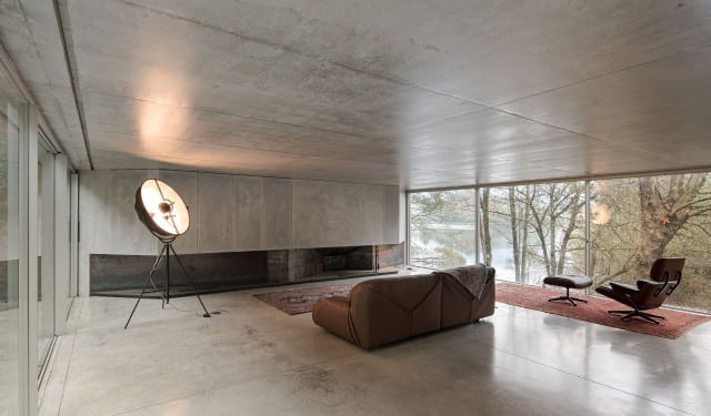 Casa en Caniçada. Interior de la zona social con el salón, sofá e iluminación. Carvalho Araújo | Alumilux