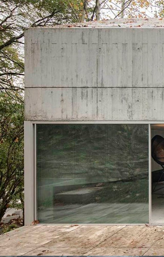 Casa en Caniçada. Vista frontal de la vivienda donde se combina el vidrio y el homrmigón. Carvalho Araújo | Alumilux