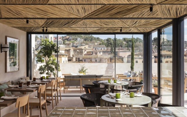 Hotel Casa Cacao | Zona interior de la terraza equipada con ventanas Ottima y con vistas sobre la ciudad de Girona | cAllís mArès arquitectes