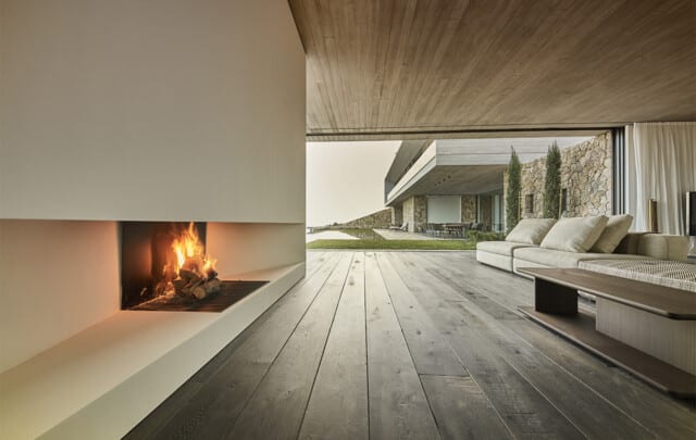 RV47 | Salón con chimenea y sofá con pavimento de madera | AVW Arquitectos | Alumilux